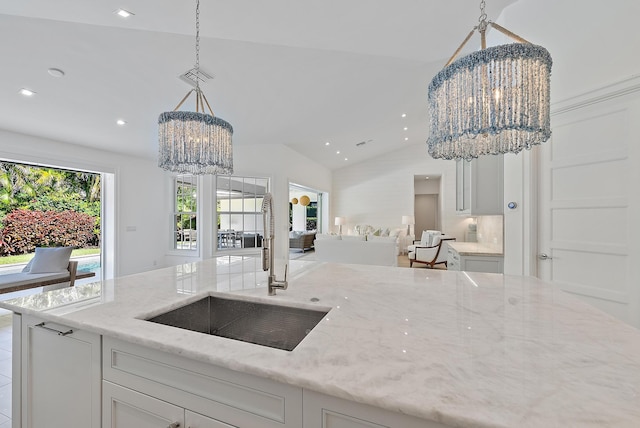 189 Shelter Ln, Jupiter Inlet Colony, FL 33469 - kitchen with a chandelier, open floor plan, light stone counters, decorative light fixtures, and vaulted ceiling