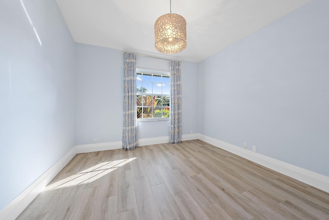 189 Shelter Ln, Jupiter Inlet Colony, FL 33469 - unfurnished room with baseboards, wood finished floors, and a notable chandelier