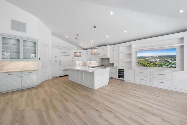 189 Shelter Ln, Jupiter Inlet Colony, FL 33469 - kitchen with wine cooler, paneled refrigerator, lofted ceiling, decorative backsplash, and light countertops
