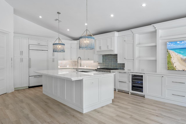 189 Shelter Ln, Jupiter Inlet Colony, FL 33469 - kitchen with beverage cooler, open shelves, paneled refrigerator, a chandelier, and light wood-style flooring