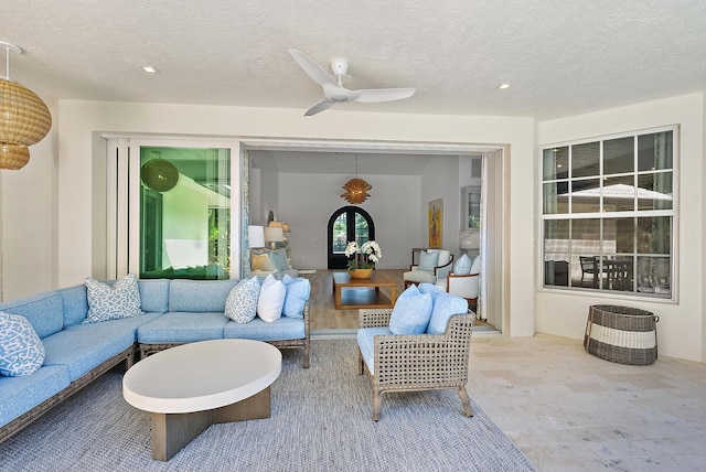 living room featuring a textured ceiling and ceiling fan