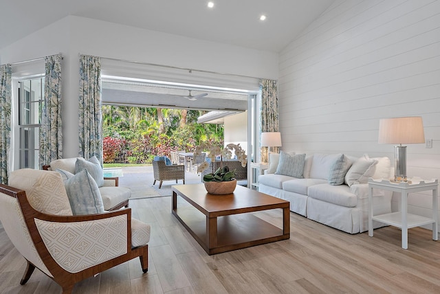 living room featuring vaulted ceiling, ceiling fan, and light hardwood / wood-style floors