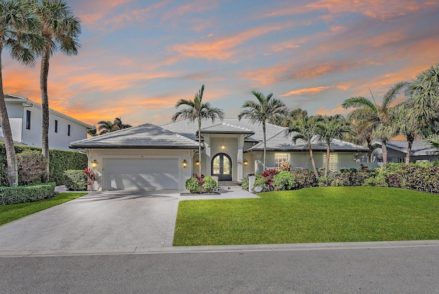 189 Shelter Ln, Jupiter Inlet Colony, FL 33469 - view of front of house with a tile roof, a front lawn, driveway, an attached garage, and stucco siding