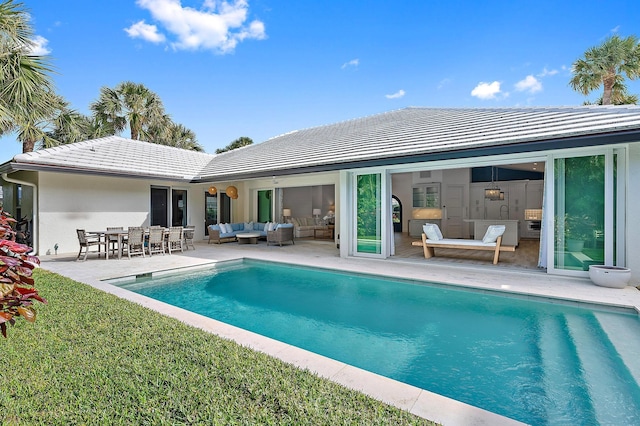 189 Shelter Ln, Jupiter Inlet Colony, FL 33469 - rear view of property with outdoor lounge area, an outdoor pool, a tiled roof, a yard, and stucco siding