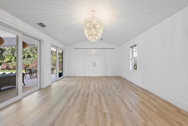 189 Shelter Ln, Jupiter Inlet Colony, FL 33469 - spare room with light wood-style floors, a chandelier, vaulted ceiling, and a barn door