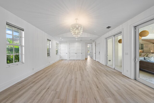 189 Shelter Ln, Jupiter Inlet Colony, FL 33469 - unfurnished living room with a chandelier, light wood-style floors, plenty of natural light, and lofted ceiling