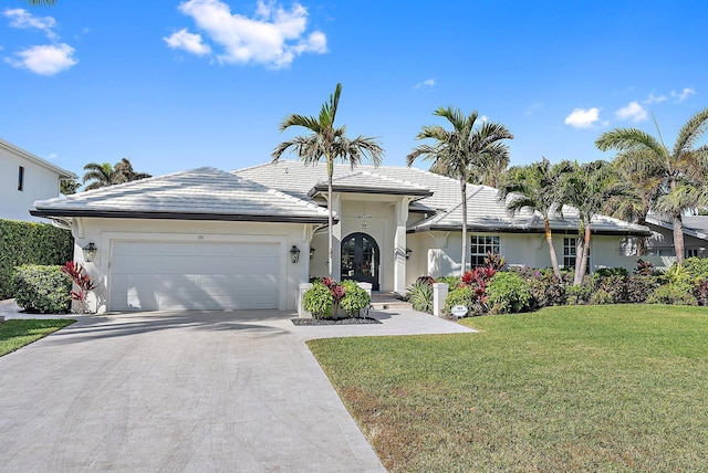 189 Shelter Ln, Jupiter Inlet Colony, FL 33469 - single story home featuring an attached garage, a front yard, driveway, stucco siding, and french doors