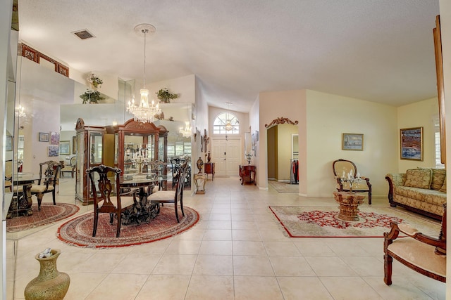 tiled dining area featuring a textured ceiling, a chandelier, and high vaulted ceiling