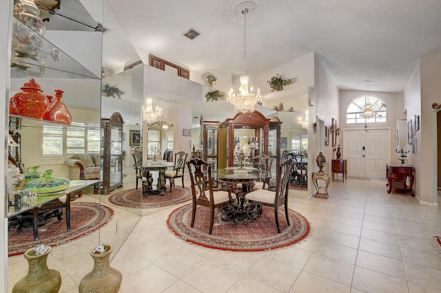 dining space with light tile patterned floors, high vaulted ceiling, and a notable chandelier