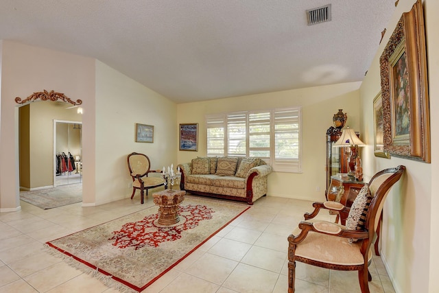 tiled living room with a textured ceiling and vaulted ceiling