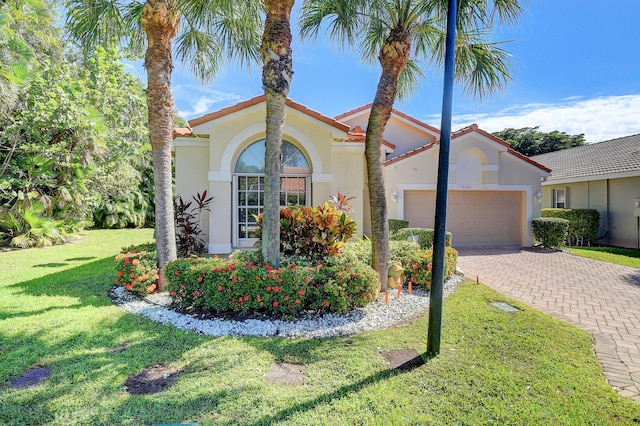 mediterranean / spanish home featuring a front lawn and a garage