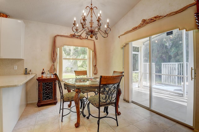 dining area with a textured ceiling, light tile patterned floors, and a chandelier