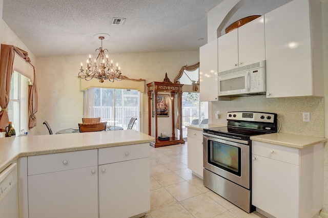 kitchen with light tile patterned floors, decorative light fixtures, white appliances, a chandelier, and white cabinets