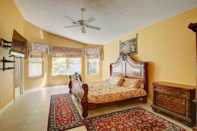 tiled bedroom with vaulted ceiling, ceiling fan, and a textured ceiling