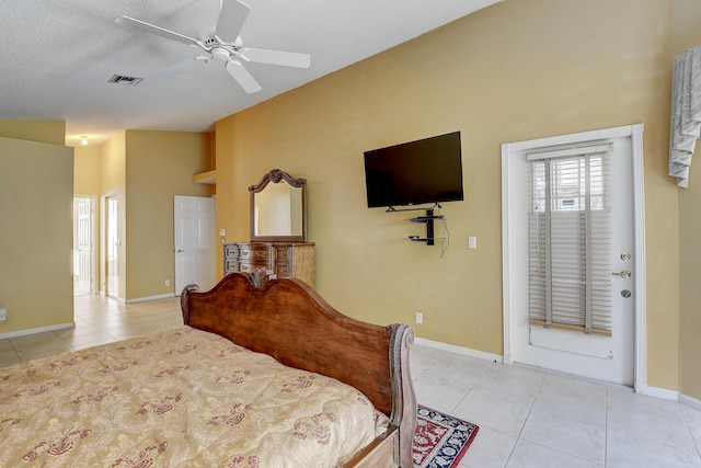 tiled bedroom with a textured ceiling, ceiling fan, and vaulted ceiling