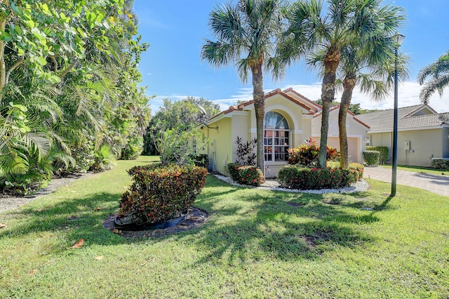 mediterranean / spanish-style house with a garage and a front lawn