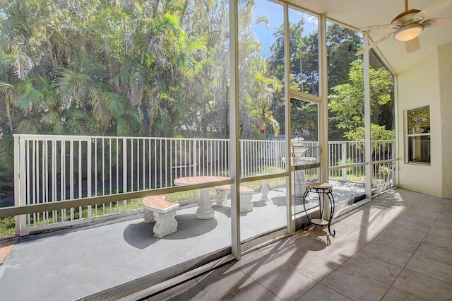 unfurnished sunroom with ceiling fan, a wealth of natural light, and lofted ceiling