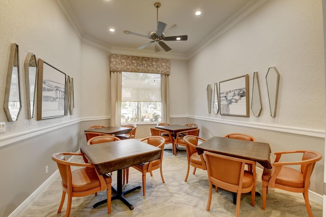 dining space featuring ceiling fan, crown molding, and light colored carpet