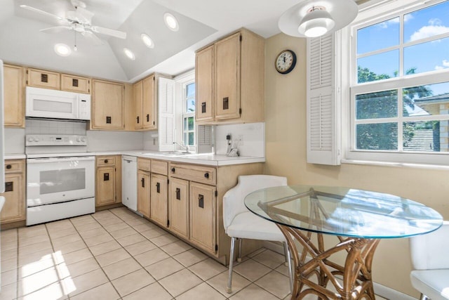 kitchen featuring a wealth of natural light, sink, light tile patterned floors, and white appliances