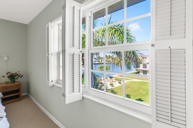 interior space featuring a water view and carpet