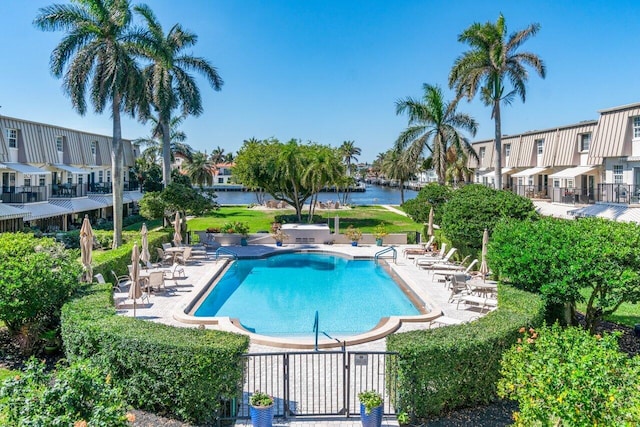 view of pool with a patio area and a water view