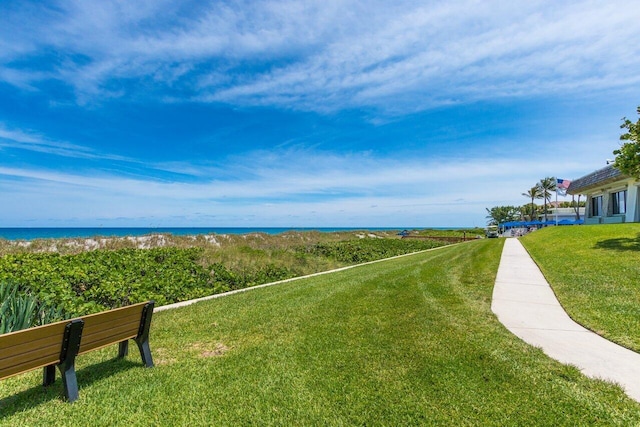 surrounding community featuring a water view and a lawn