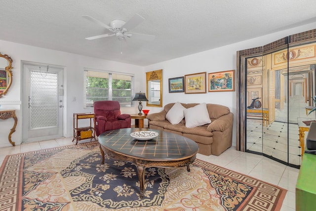 tiled living room featuring ceiling fan and a textured ceiling