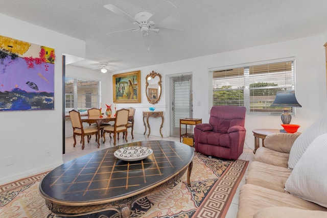 tiled living room with ceiling fan and a textured ceiling