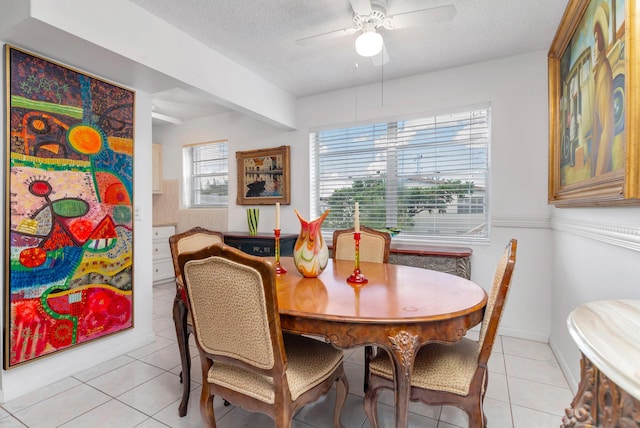 dining area featuring light tile patterned flooring, plenty of natural light, and a textured ceiling