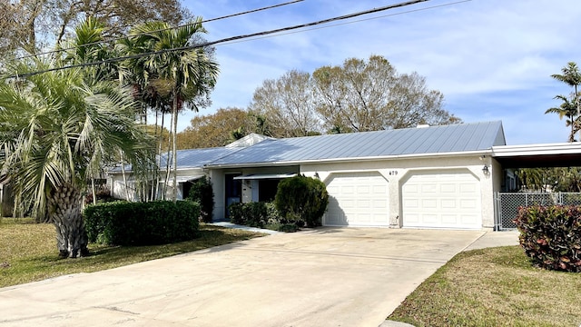 479 SE Verada Ave, Port Saint Lucie, FL 34983 - ranch-style home with a garage, metal roof, concrete driveway, and stucco siding