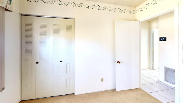 479 SE Verada Ave, Port Saint Lucie, FL 34983 - unfurnished bedroom with light carpet, visible vents, a closet, and light tile patterned floors