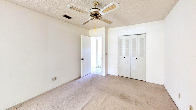 479 SE Verada Ave, Port Saint Lucie, FL 34983 - unfurnished bedroom featuring visible vents, ceiling fan, carpet flooring, a closet, and a textured ceiling