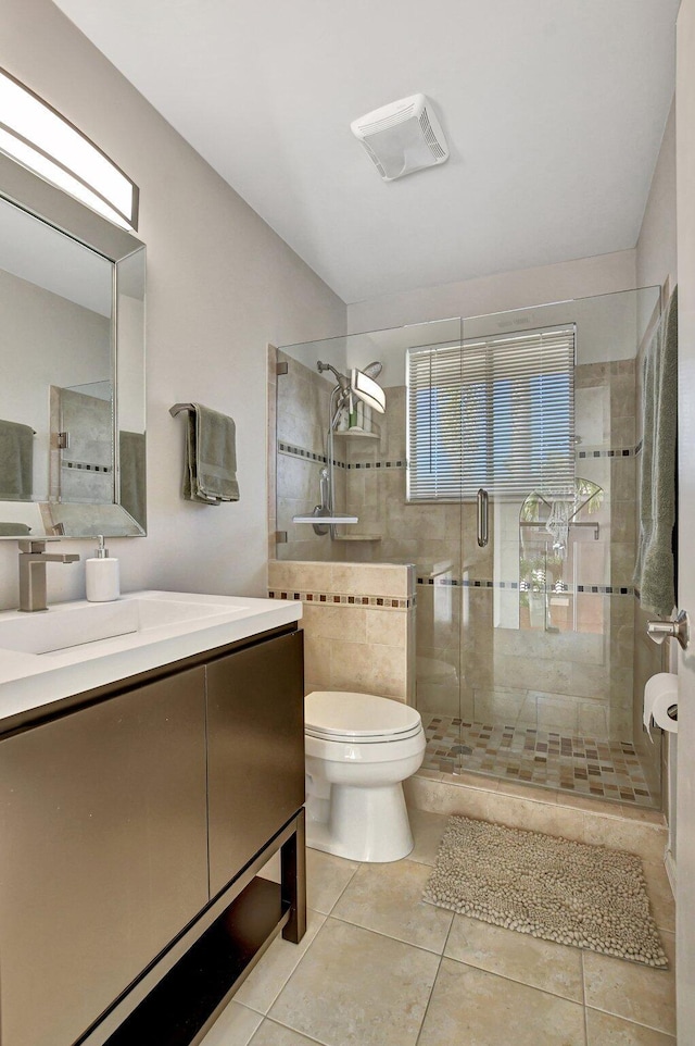 bathroom featuring walk in shower, vanity, tile patterned floors, and toilet