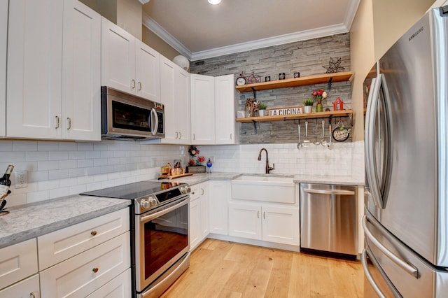 kitchen with sink, light stone countertops, white cabinets, and appliances with stainless steel finishes