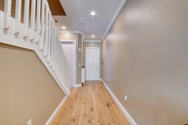 hallway with ornamental molding and light hardwood / wood-style floors