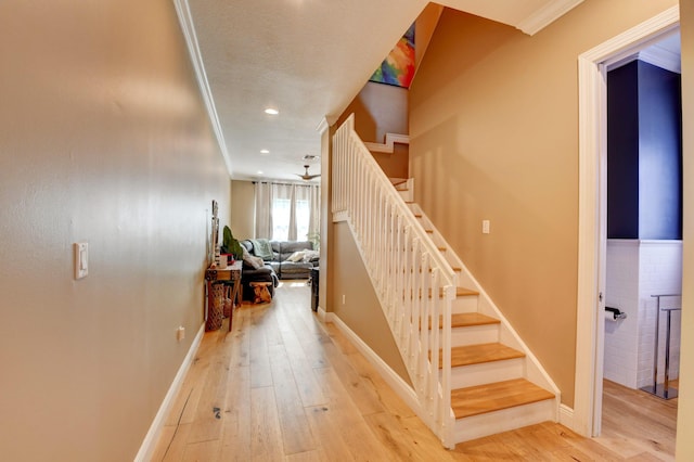 staircase with crown molding and hardwood / wood-style flooring