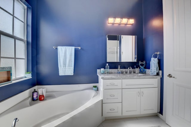 bathroom with tile patterned floors, a bath, and vanity