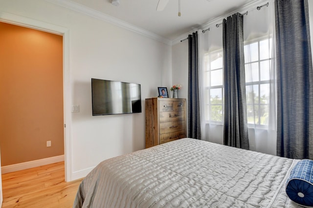 bedroom featuring hardwood / wood-style flooring, ornamental molding, and ceiling fan