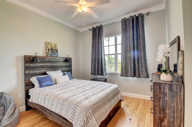 bedroom featuring ceiling fan, ornamental molding, and light wood-type flooring