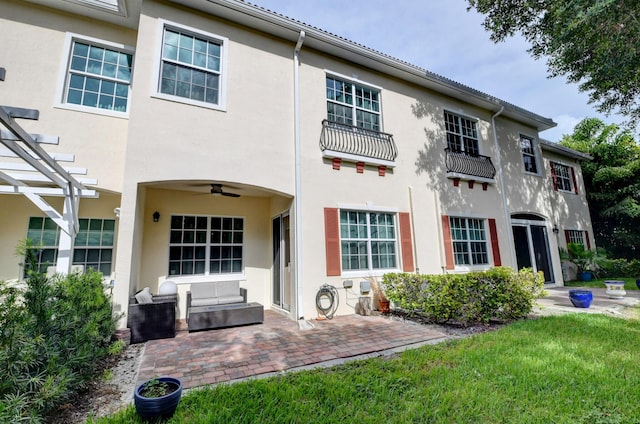 rear view of house featuring a pergola, a patio area, ceiling fan, and a lawn