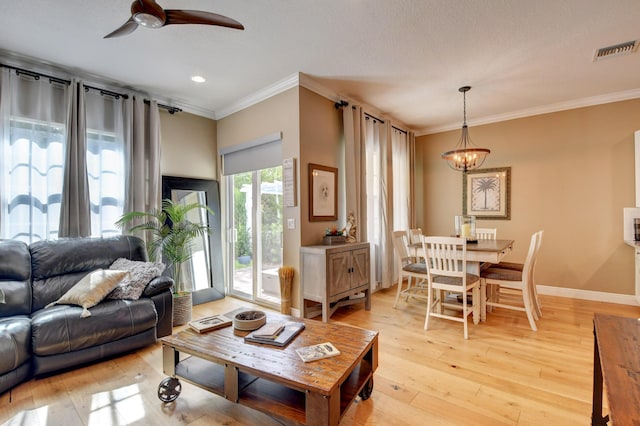 living room featuring crown molding, ceiling fan with notable chandelier, and light hardwood / wood-style floors