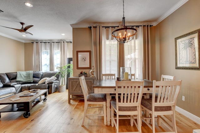 dining space with crown molding, ceiling fan with notable chandelier, light hardwood / wood-style floors, and a textured ceiling