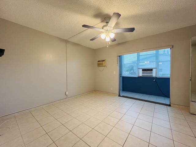 unfurnished room with a wall unit AC, ceiling fan, cooling unit, light tile patterned flooring, and a textured ceiling