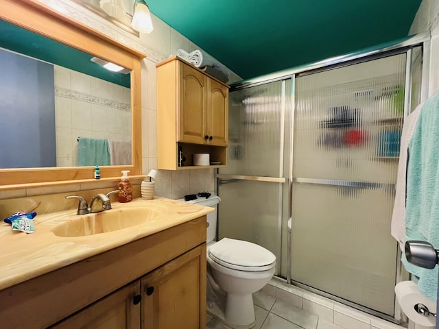 bathroom featuring toilet, tile patterned flooring, walk in shower, and vanity