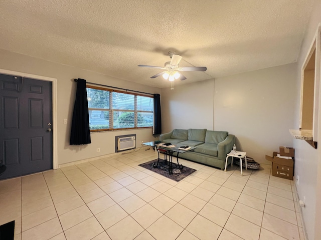 living room featuring ceiling fan, a textured ceiling, a wall unit AC, and light tile patterned flooring