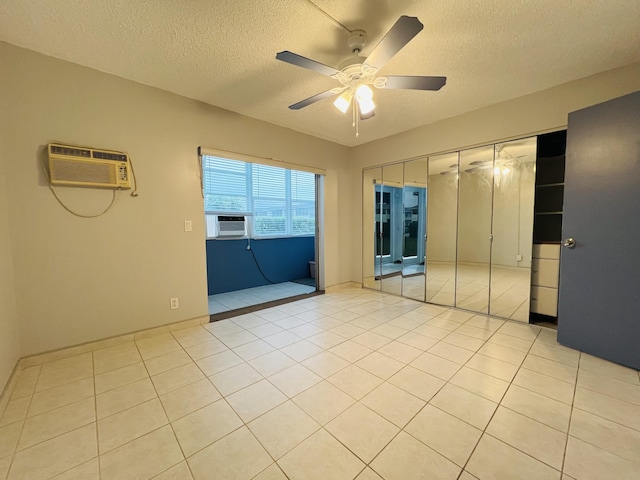 interior space with cooling unit, a closet, a wall mounted AC, light tile patterned flooring, and ceiling fan