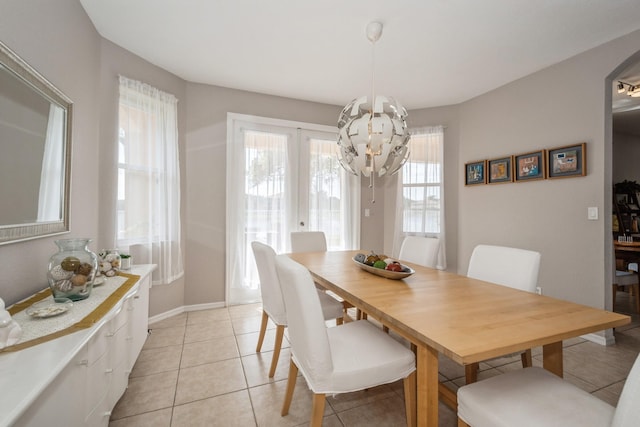 tiled dining space with french doors and an inviting chandelier