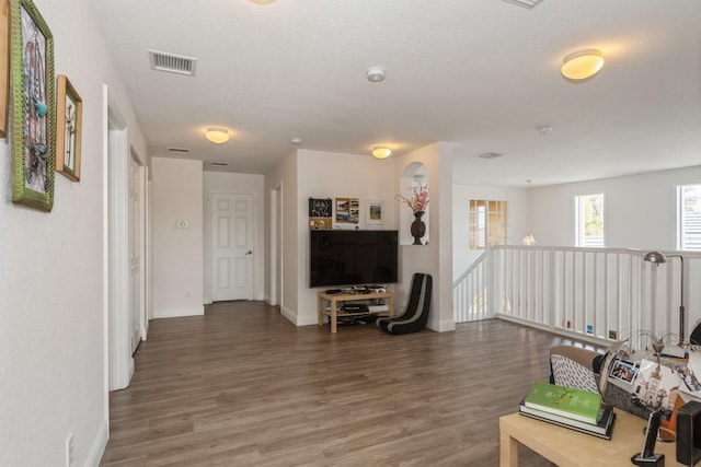 interior space with a textured ceiling and dark hardwood / wood-style floors