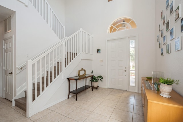 entrance foyer with light tile patterned floors and a high ceiling