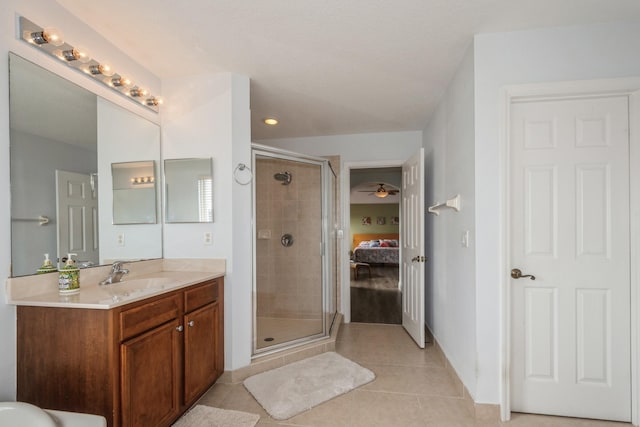 bathroom with a shower with shower door, tile patterned floors, vanity, and ceiling fan